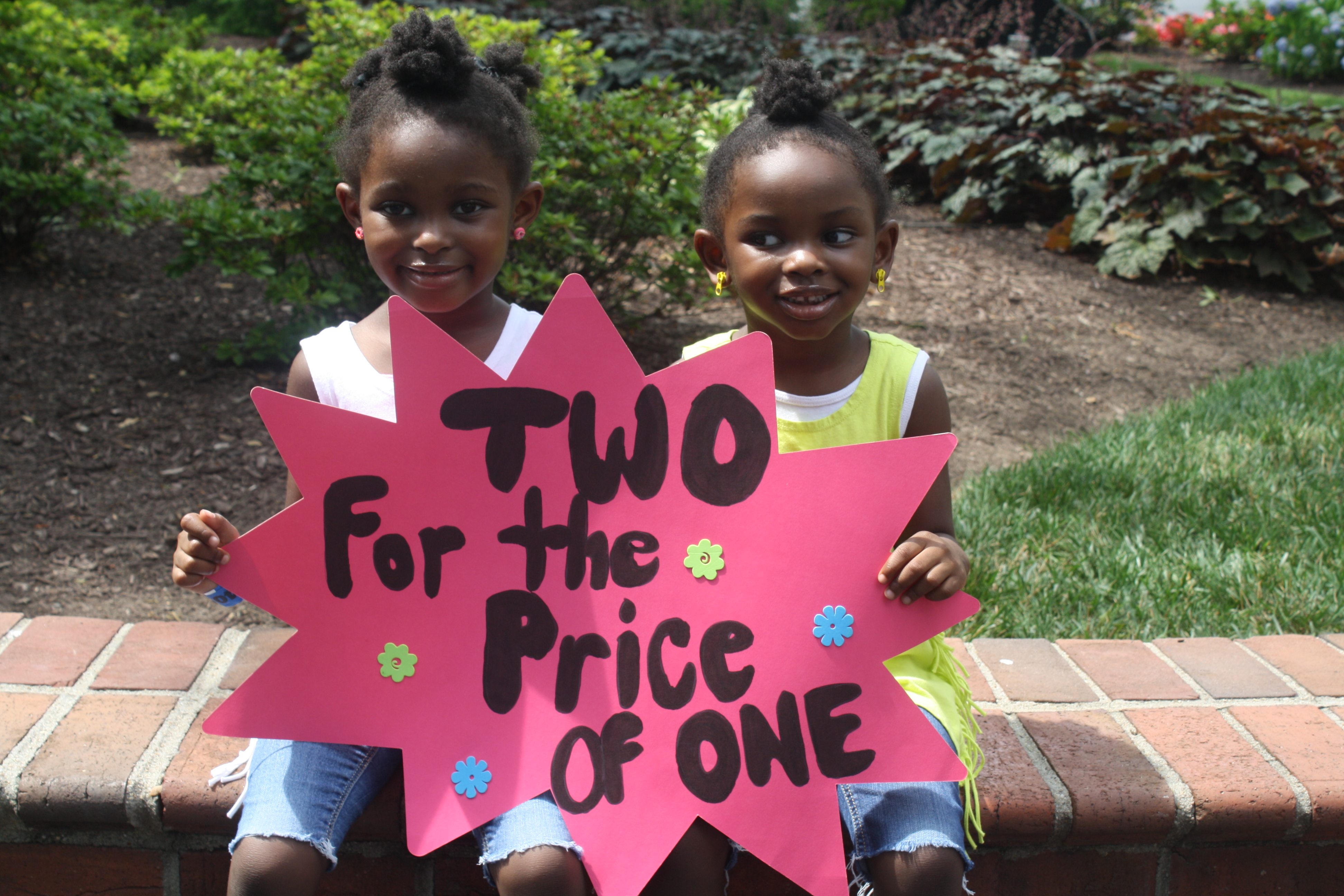 Twin african american girls holding up a sign 
